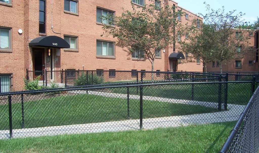 A brick building with a black fence in front.